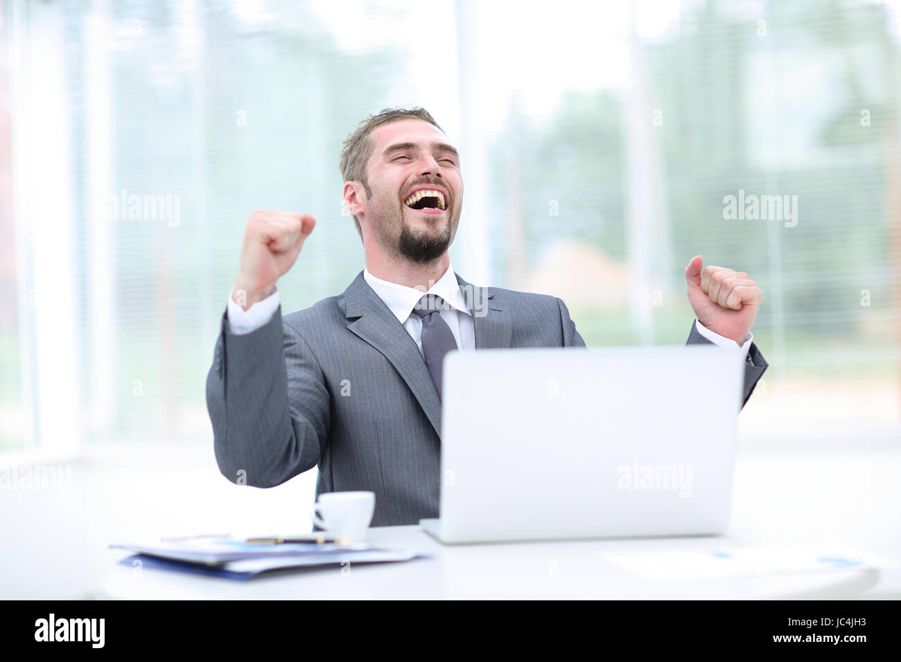 Portrait of happy businessman cheering at workplace Stock Photo - Alamy