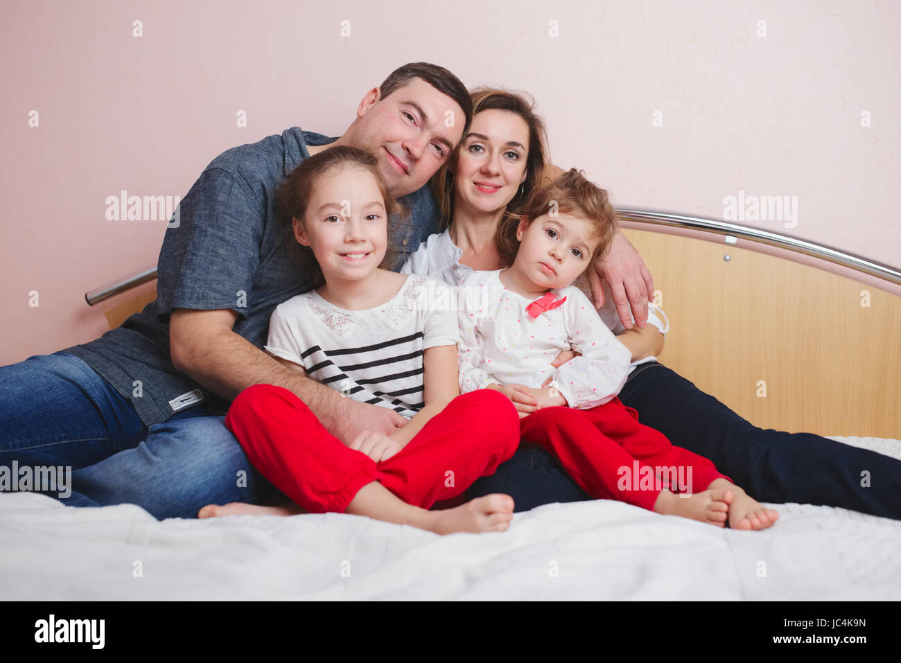 young family lying in bed at home Stock Photo