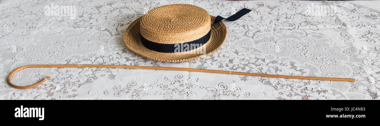 school cane and boater resting on lace tablecloth Stock Photo
