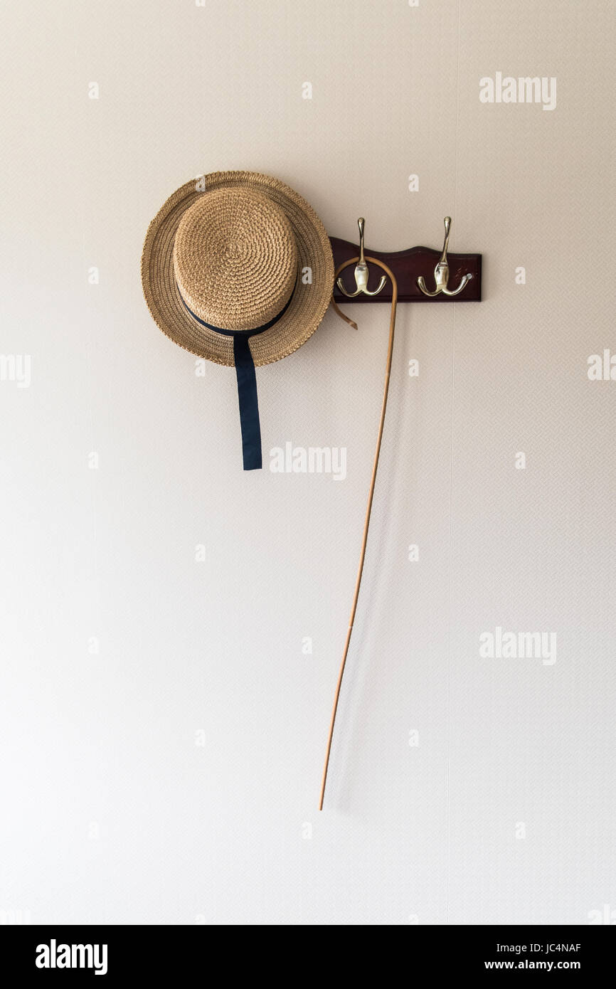 school cane and boater hanging on coat hooks Stock Photo