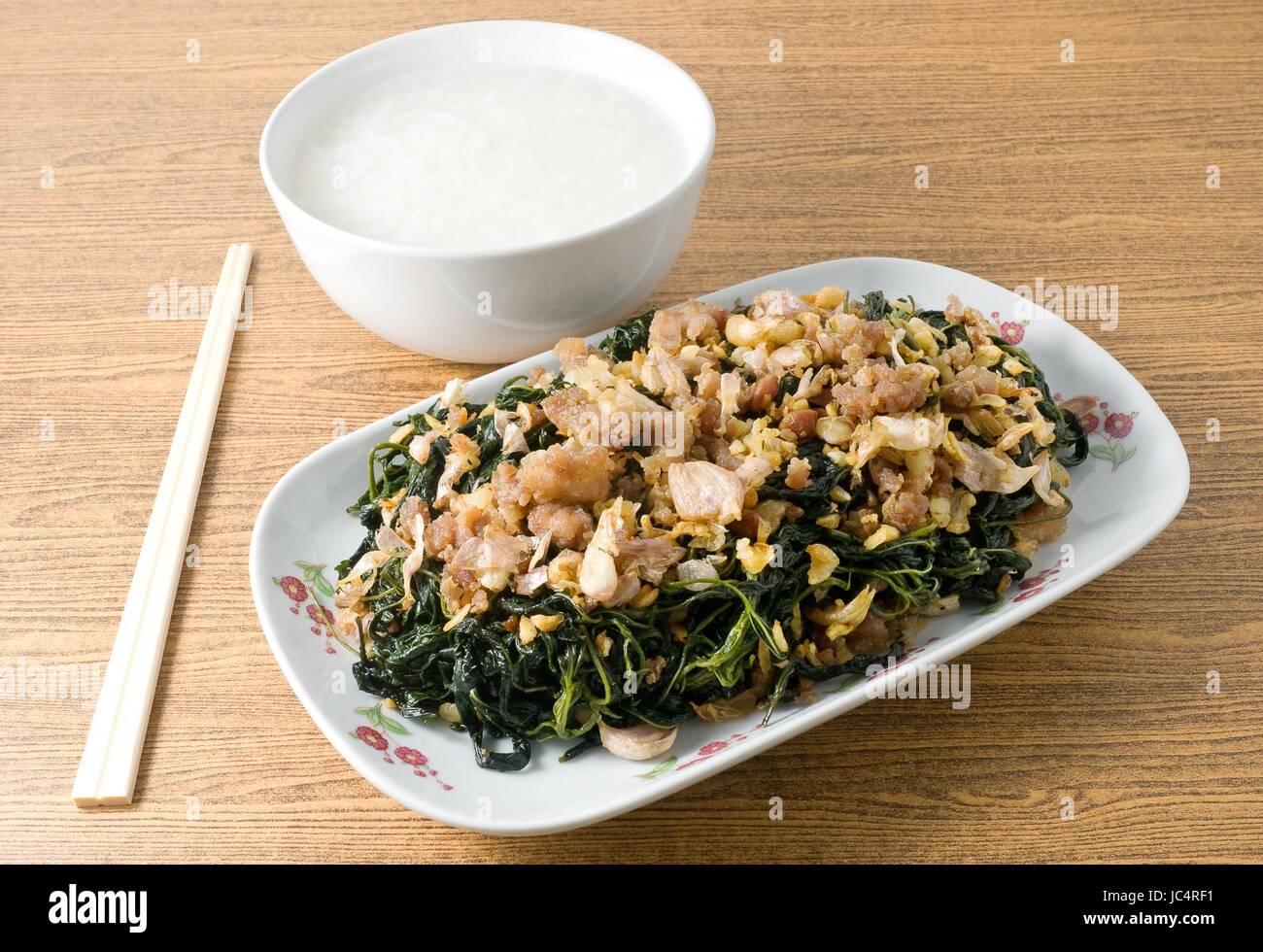 Chinese Traditional Food, Stir Fried Jute Leaves or Mulukhiyah Leaves with Minced Pork, Garlics and Fermented Soy Bean Served with Soft Boiled Rice. Stock Photo