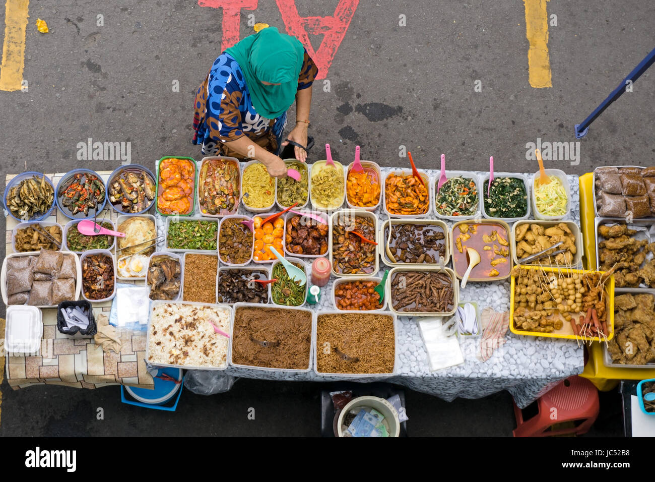 KOTA KINABALU, MALAYSIA - JUNE 10, 2017: Top view of vendor owner selling variety of cakes and dessert during Ramadan bazaar. Stock Photo