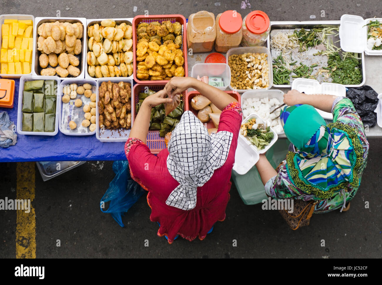 KOTA KINABALU, MALAYSIA - JUNE 10, 2017: Top view of stall vendor selling variety of Malaysian food, cakes and dessert during Ramadan bazaar. Stock Photo