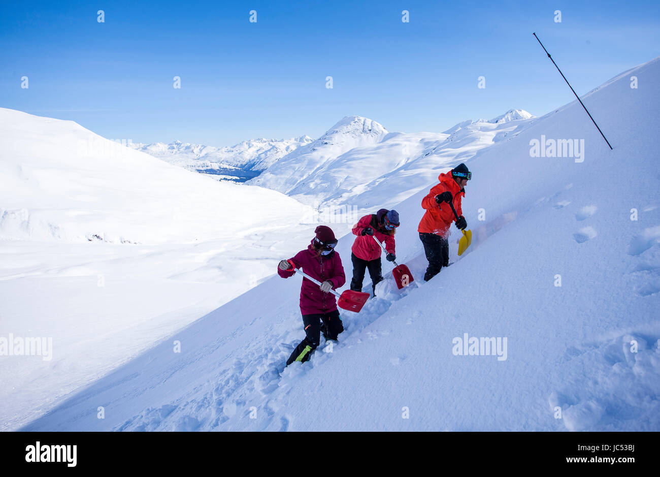 Professional snowboarders, Robin Van Gyn, Marie France Roy, and Helen  Schettini demonstrate proper shoveling technique to use during an avalanche  rescue on a sunny day in Haines, Alaska Stock Photo - Alamy