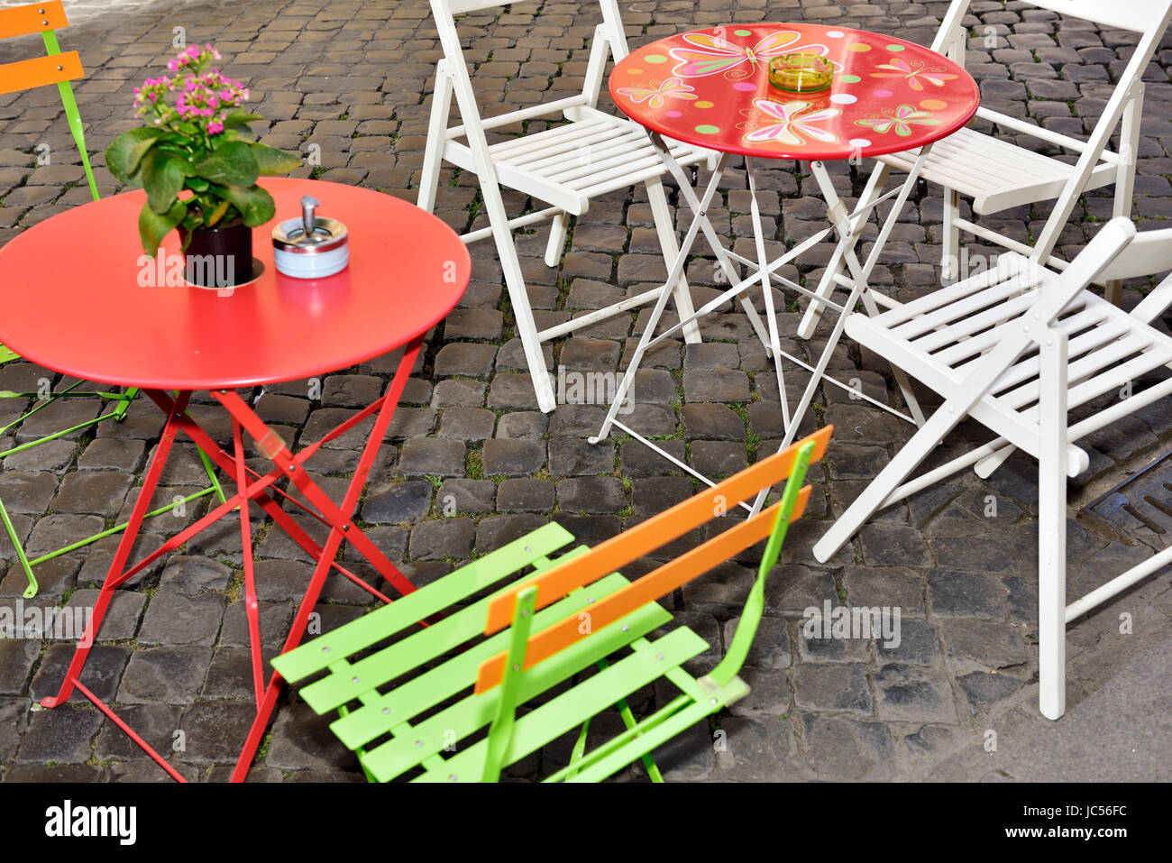 Colourful modern tables and chairs for outside eating, with ashtrays Stock Photo