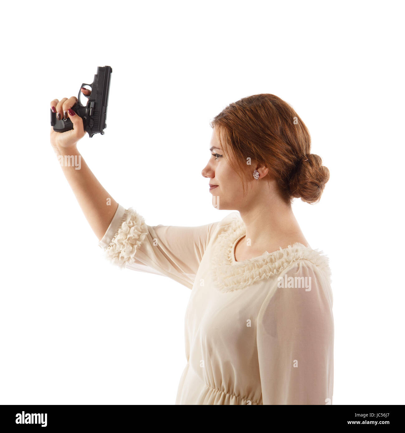 A lady wearing a white dress holding a handgun Stock Photo Alamy