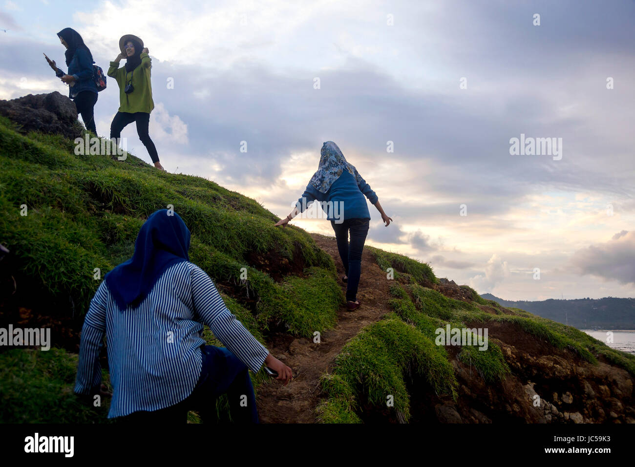 Women traveling on path up hill Stock Photo