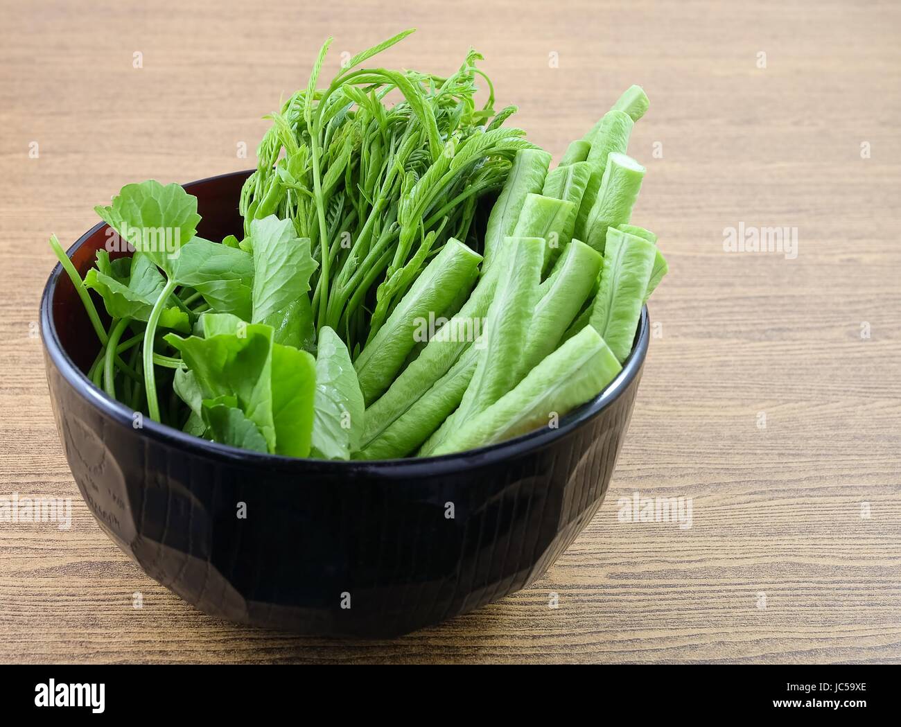 Vegetable, A Bowl of Fresh Green Cowpeas, Leucaena Leucocephala and Gotu Kola Leaves on Wooden Table with Copy Space for Text Decorated. Stock Photo