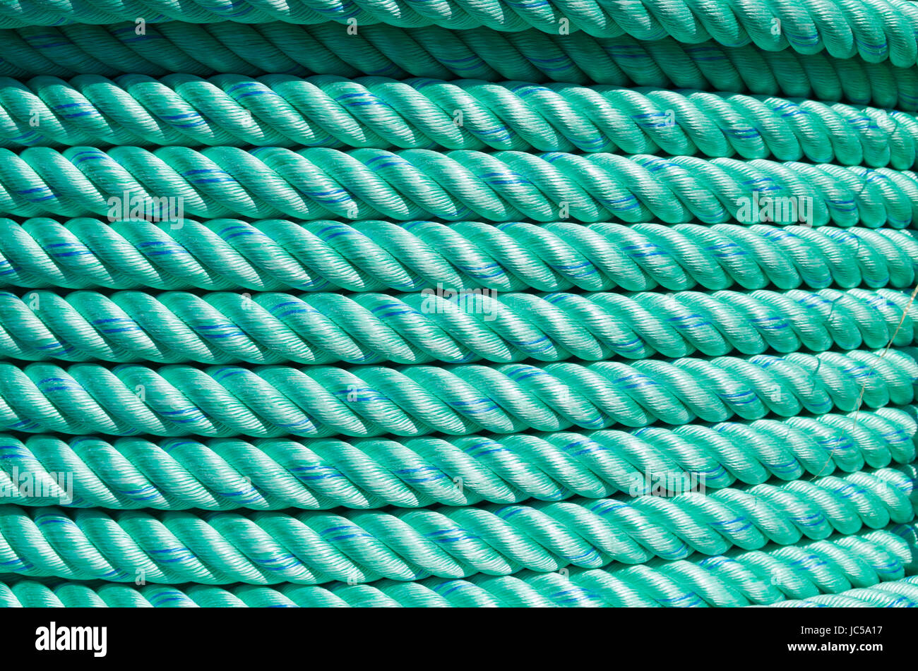 large roll with new green rope for the shipping industry Stock Photo