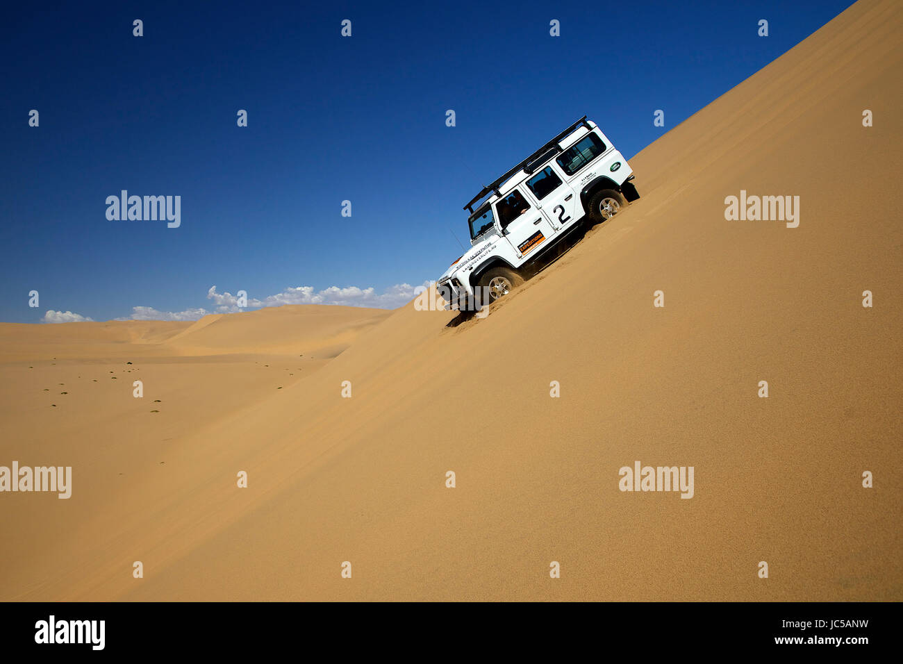 A car slides down the side of a sandy dune Stock Photo