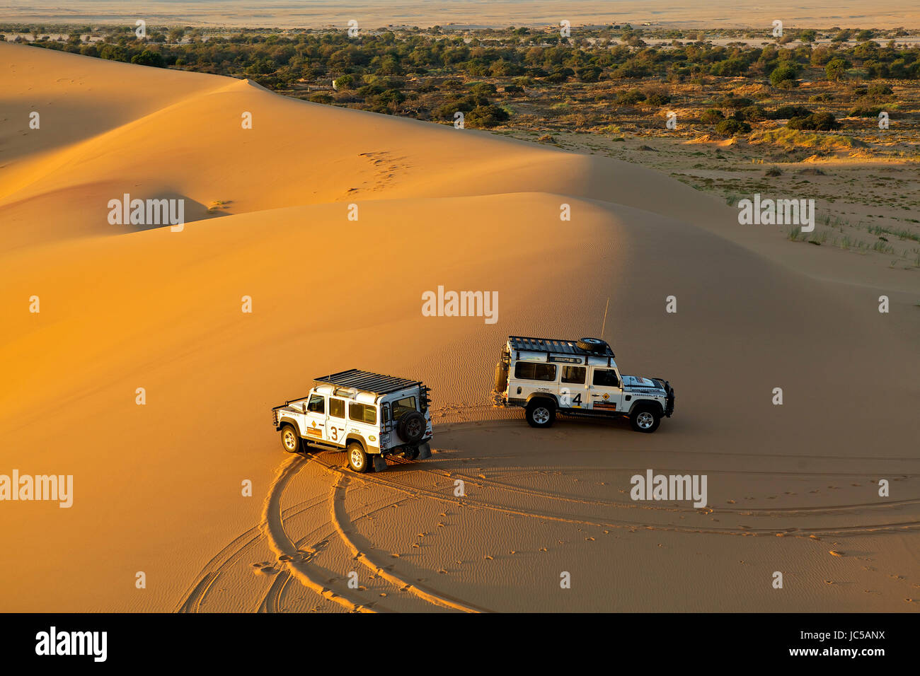 Two offroad vehicles parked on African dunes Stock Photo