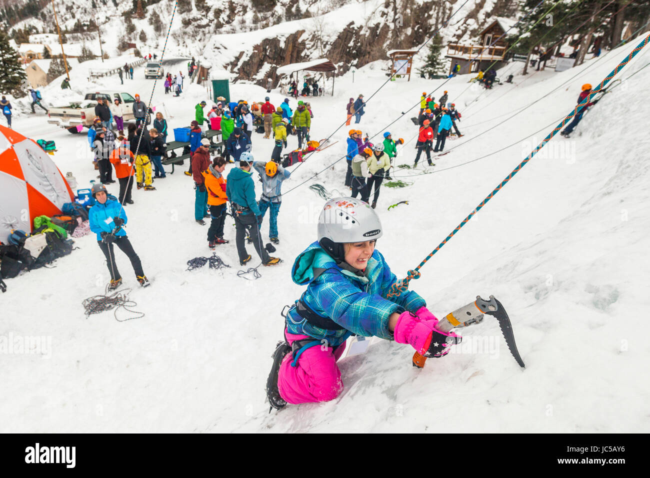 A young girl climbs ice for the first time at the Kids' Wall walk up clinics during the Ouray Ice Festival at the Ice Park, Ouray, Colorado. Stock Photo