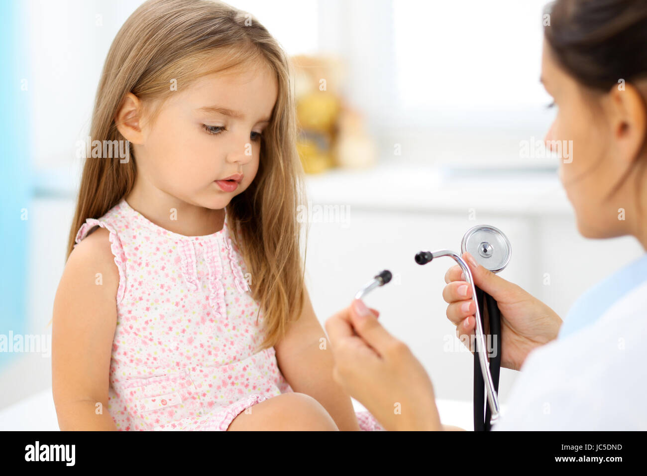 Doctor examining a little girl by stethoscope Stock Photo - Alamy