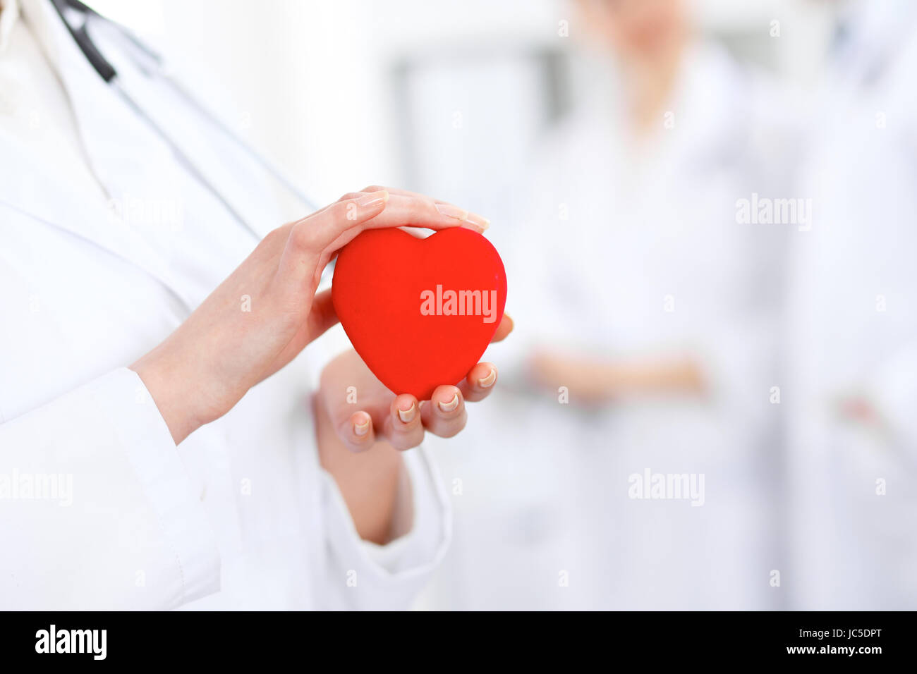 Female doctor with stethoscope holding heart Stock Photo - Alamy