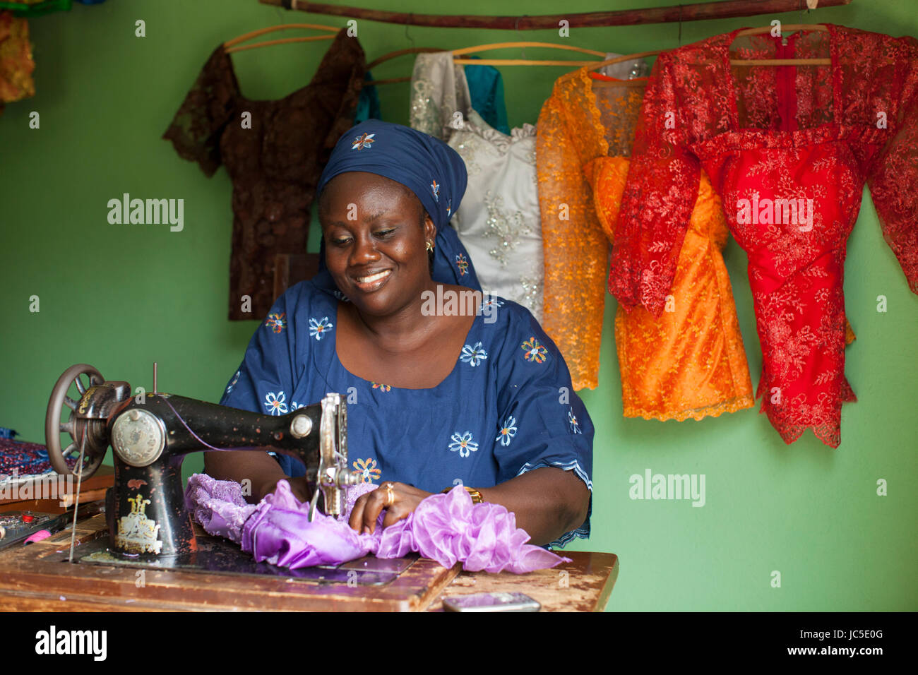 A female tailor at work at her sewing machine, Nigeria Africa Stock