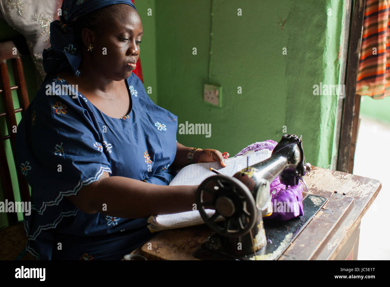 A female tailor using her sewing machine, Nigeria, Africa Stock Photo