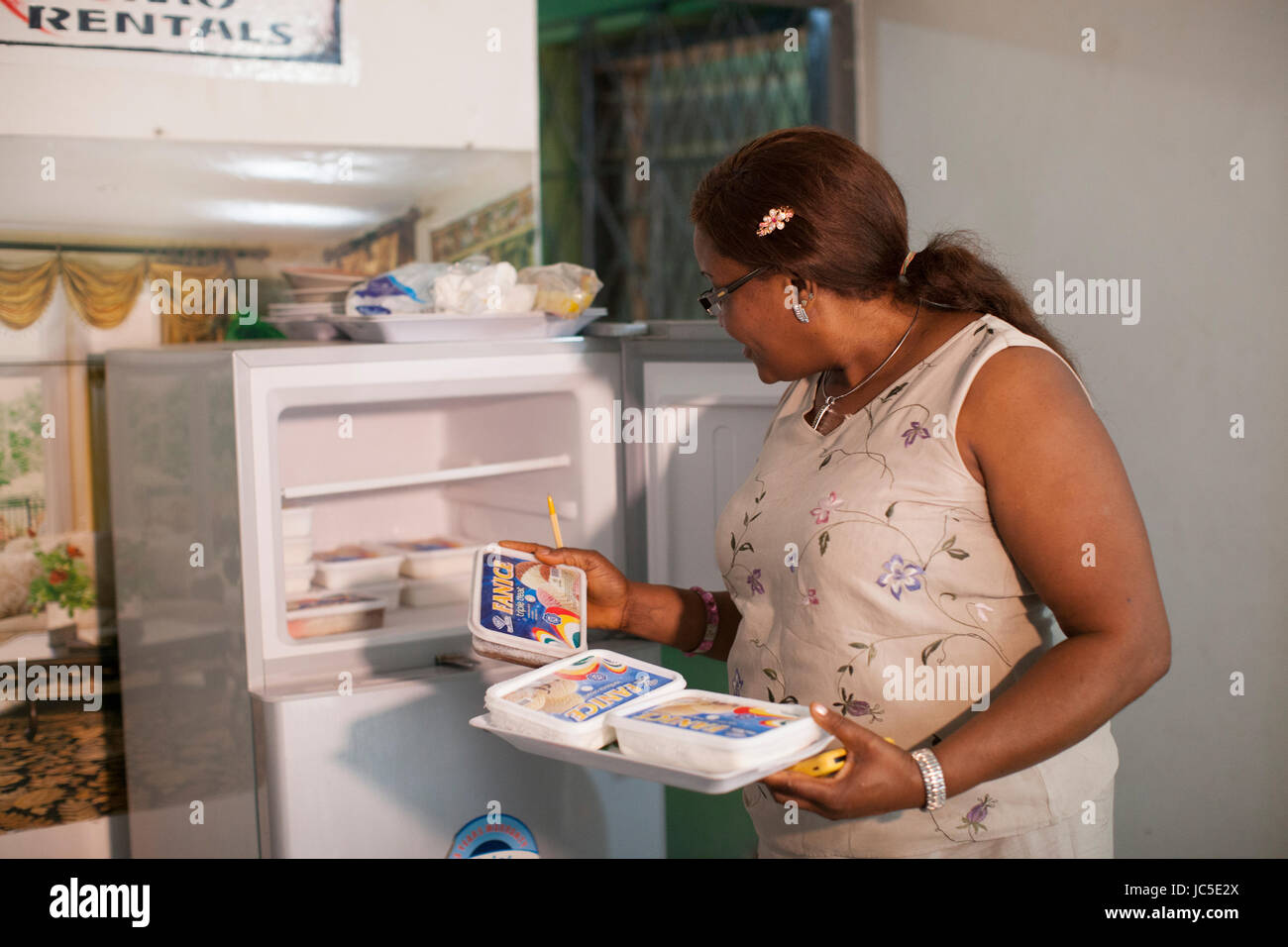 A business woman unloading her home made ice cream from the freezer. Nigeria, Africa. Stock Photo