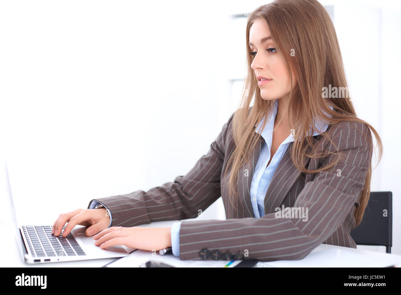 Young business woman sitting at the desk on office background Stock ...