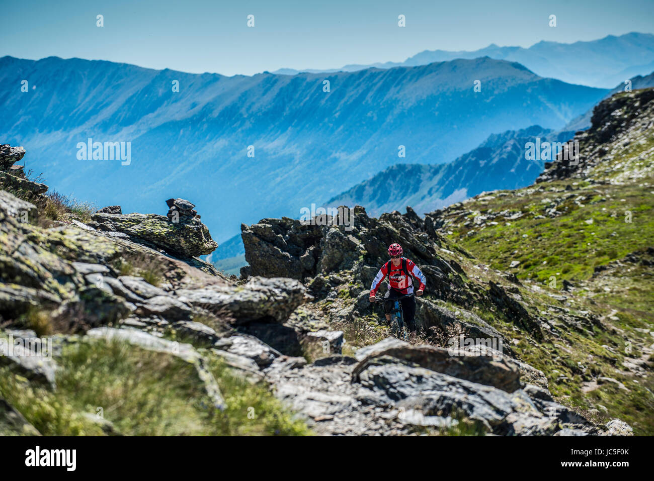 A mountain biker rides along a mountain ridge in Andorra in the Pyrenees. Stock Photo
