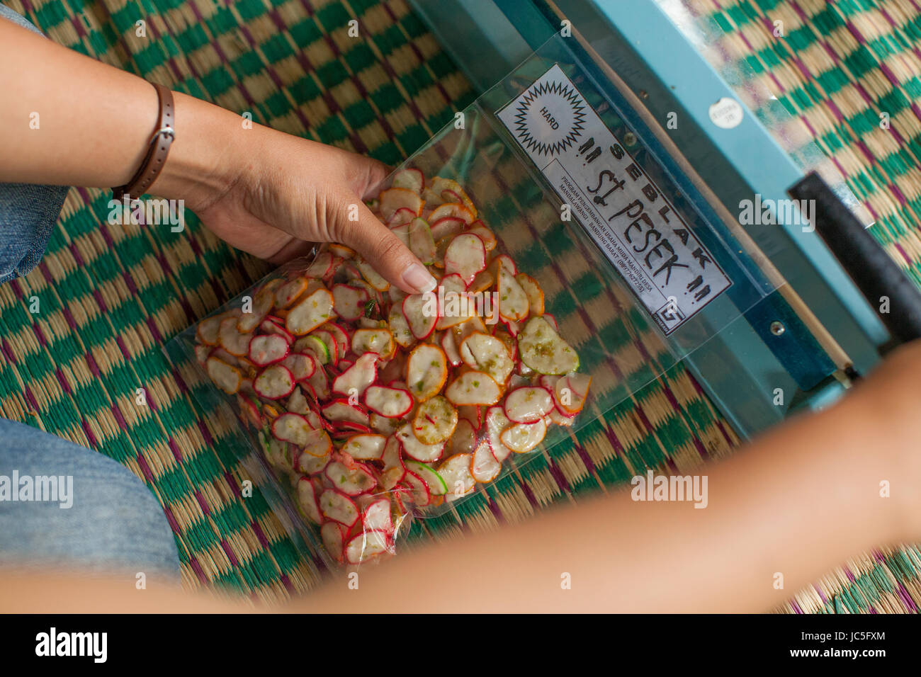 Business woman packaging up snacks to sell, Indonesia, Asia Stock Photo