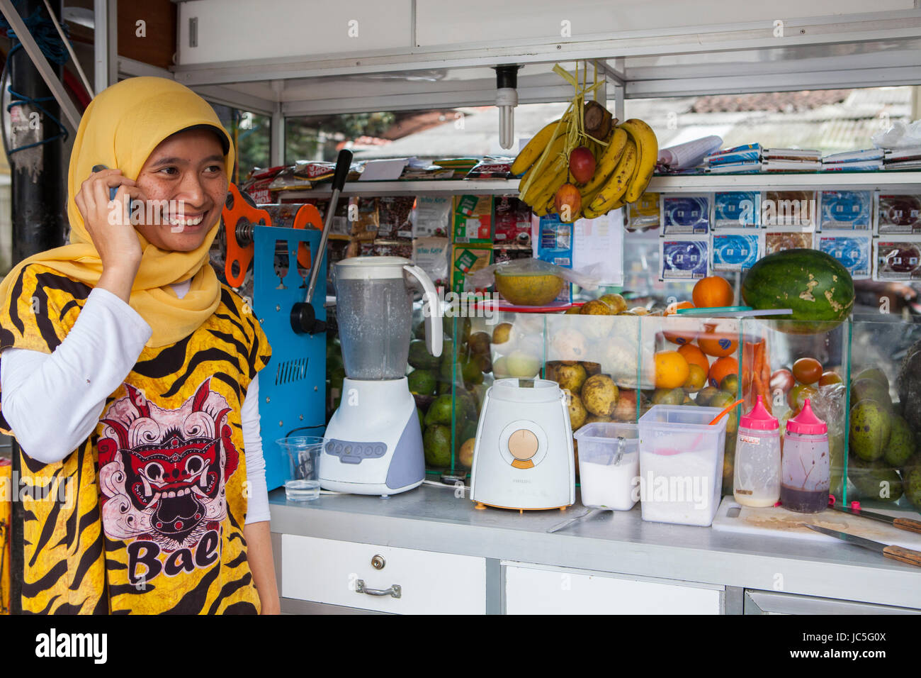 A women talking on her mobile at her smoothie shop, Indonesia, Asia. Stock Photo