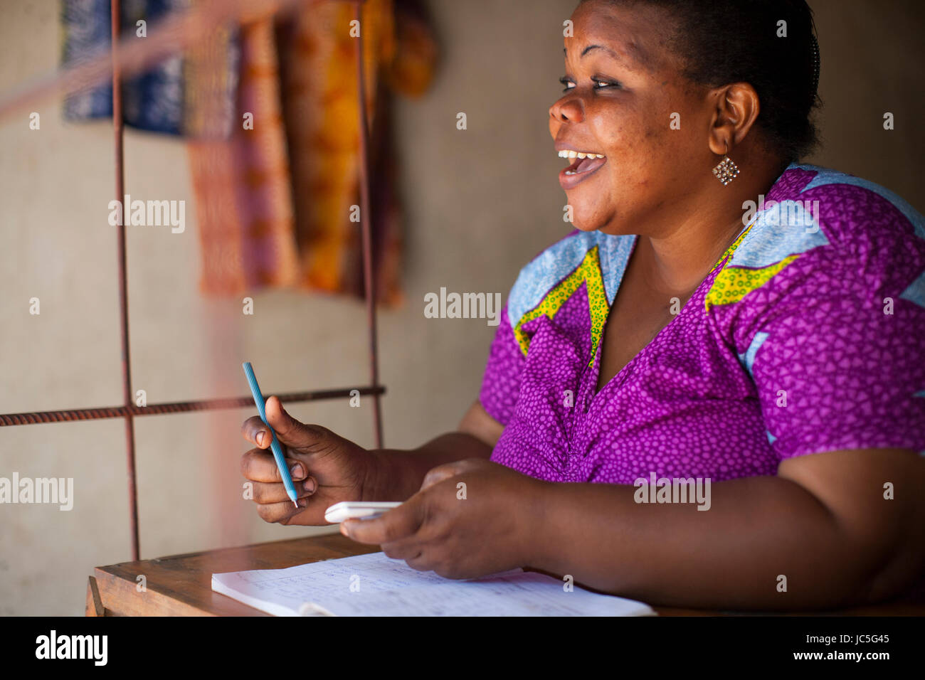 A female small business owner doing some book keeping, Tanzania, Africa Stock Photo