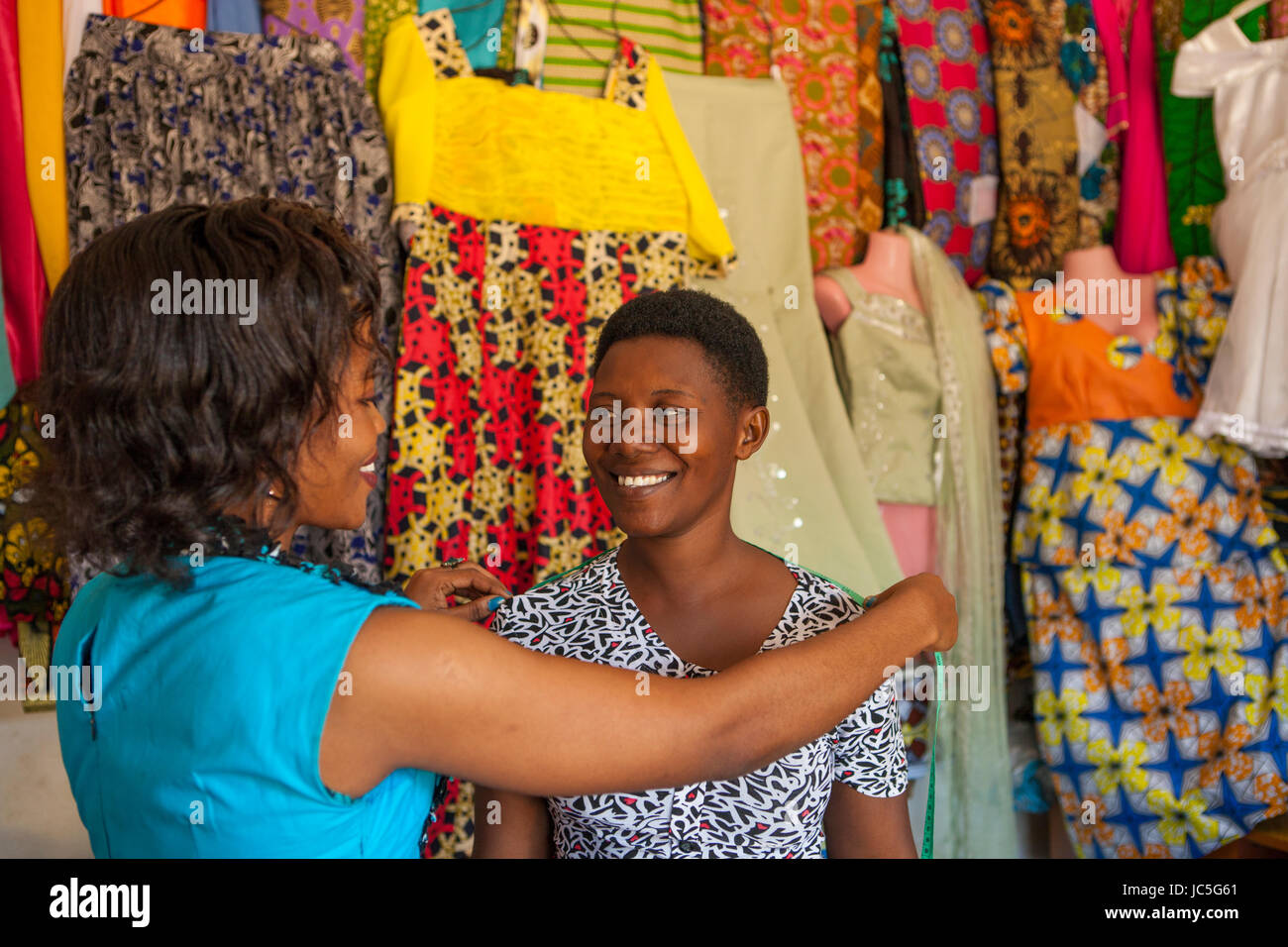 A small business female tailor measuring a customer, Tanzania, Africa. Stock Photo