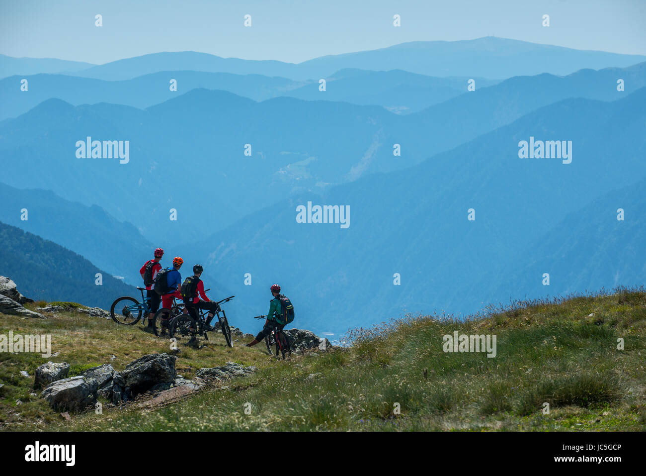 A group of mountain bikers ride a trail high in the Pyrenees, Andorra. Stock Photo
