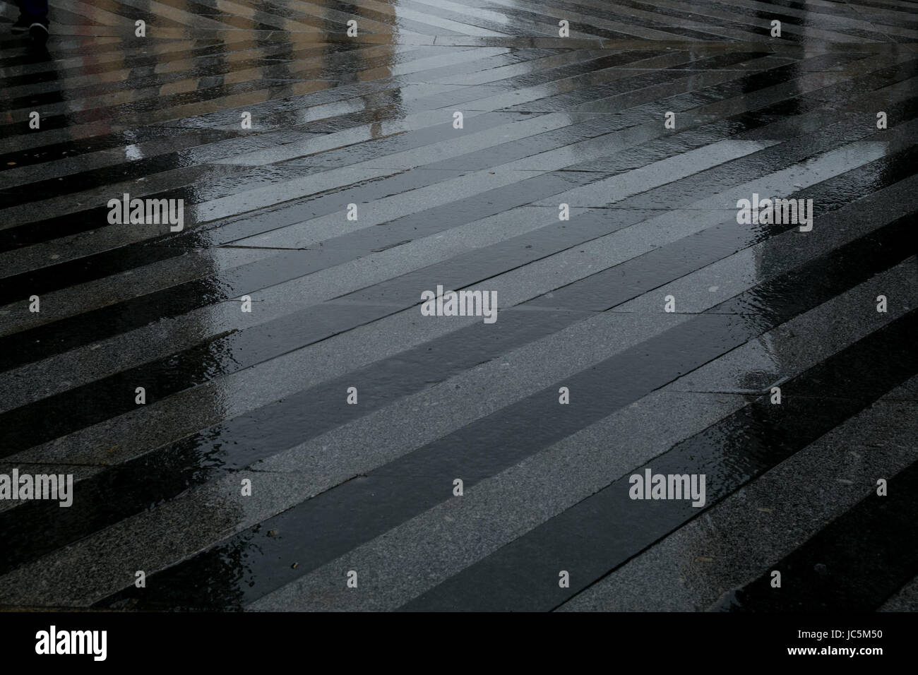Shadows of people reflected in a rainy floor Stock Photo