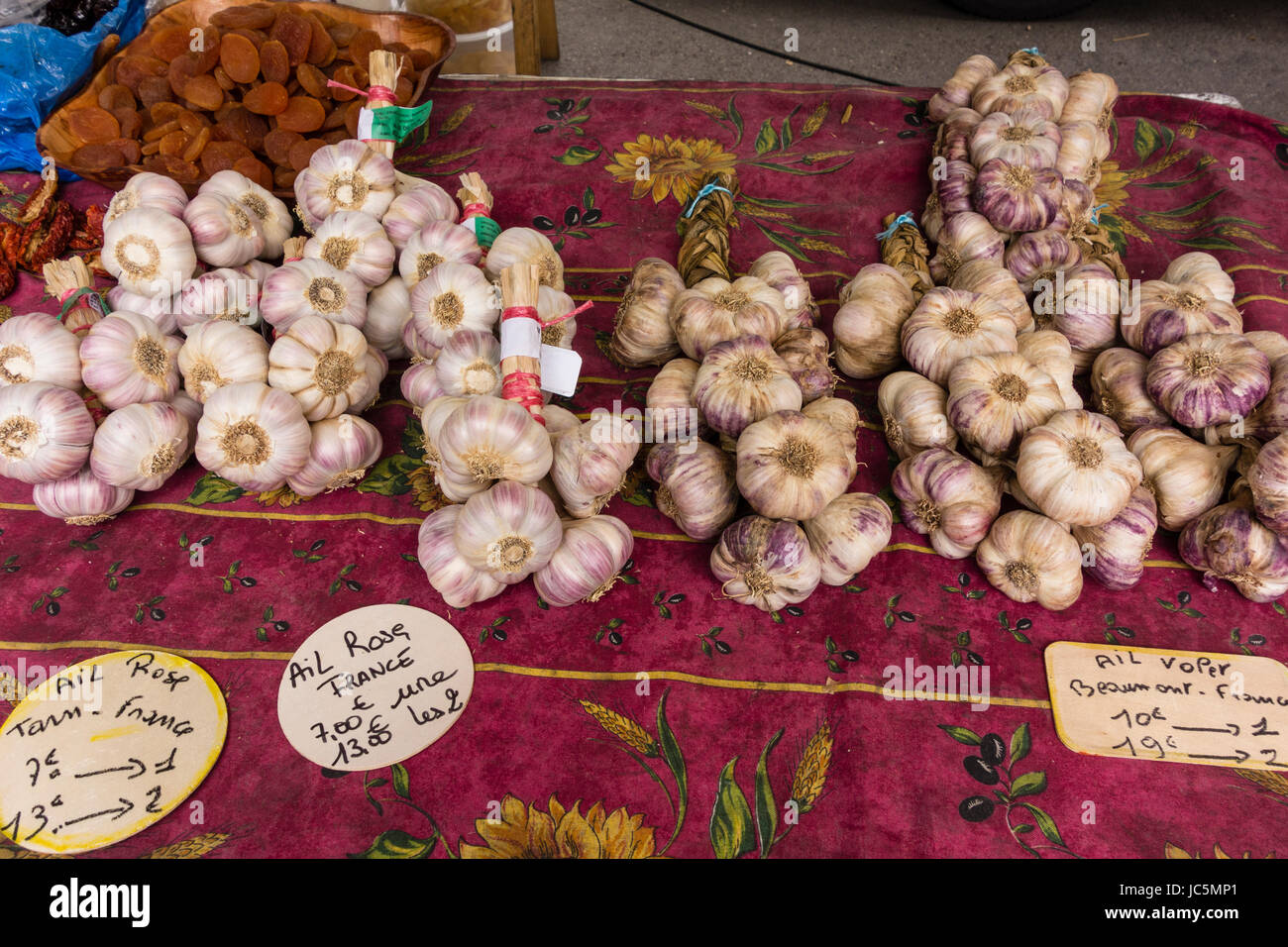 Garlic bunches displayed on a table at a outdoor market Stock Photo