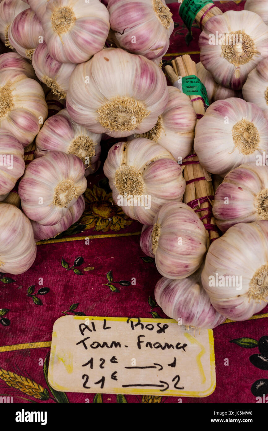 Garlic bunches (ail rose) displayed on a table at a outdoor market Stock Photo