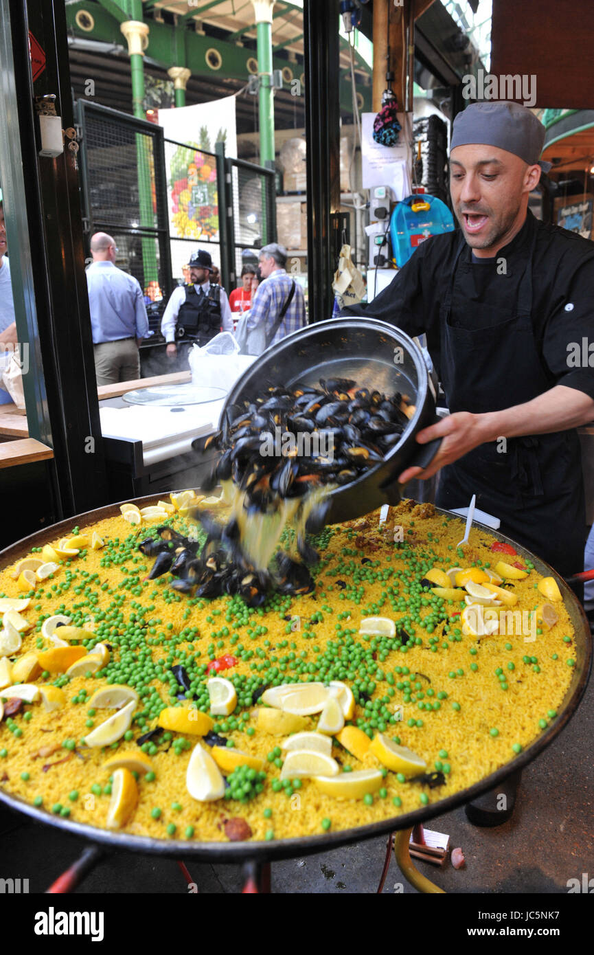 Market trader making a paella in his stall in Borough Market for the
