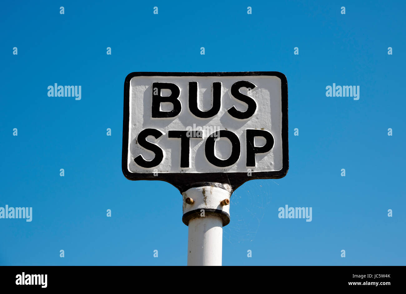 Close up of old bus stop sign with blue sky background England UK United Kingdom GB Great Britain Stock Photo