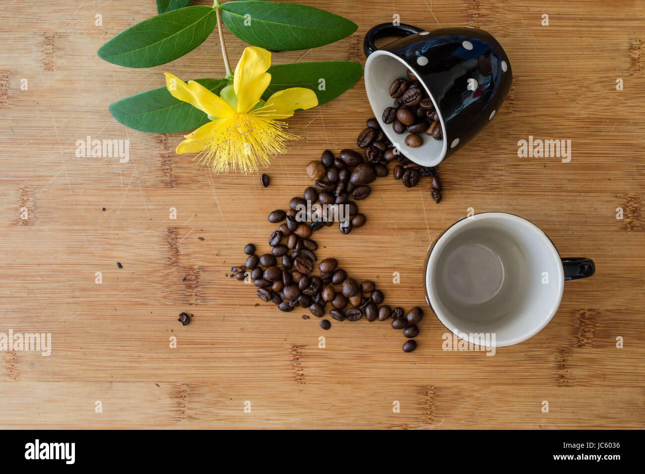 Top view of coffee beans, cup with espresso and hypericum flowers on the wooden background Stock Photo