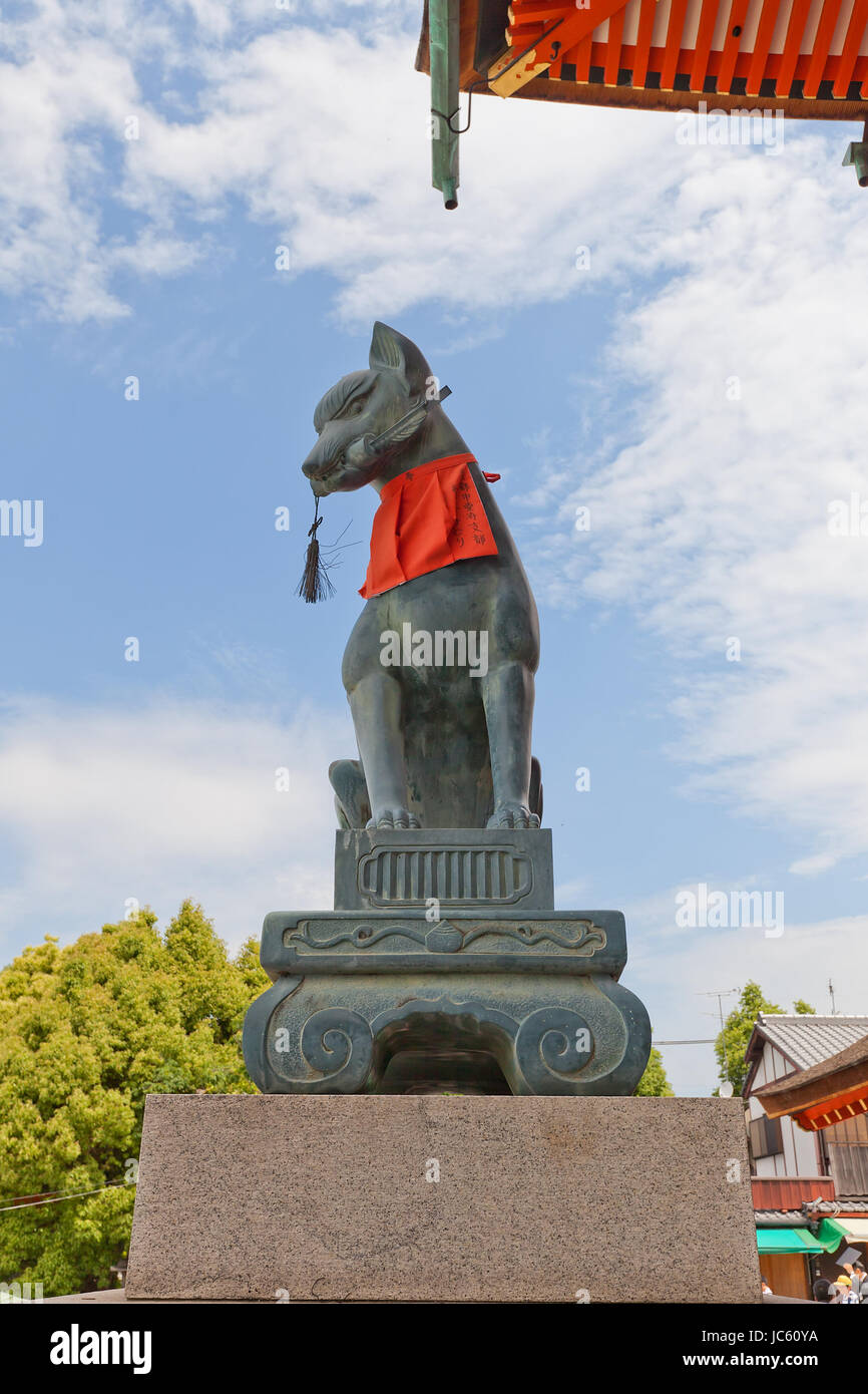 Statue of kitsune with a key in Fushimi Inari Taisha Shinto Shrine in
