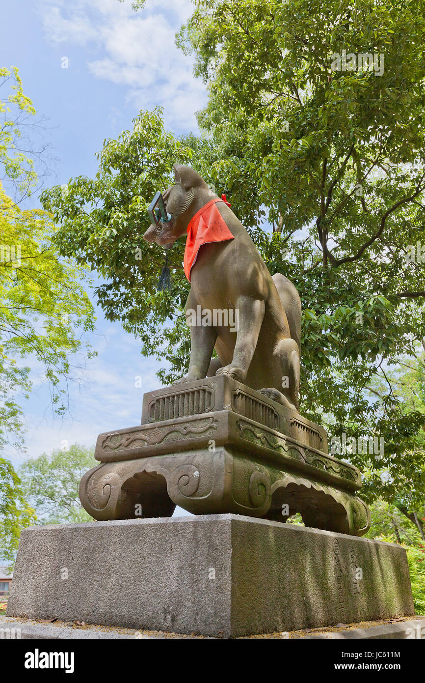 Statue of kitsune with a key in Fushimi Inari Taisha Shinto Shrine in