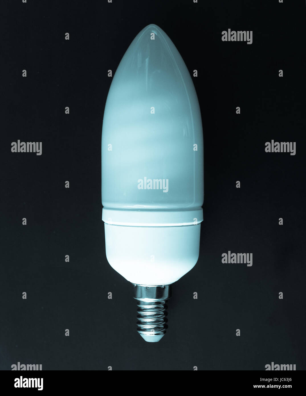 A fluorescent neon energy saving light bulb over black background cool cyanotype Stock Photo