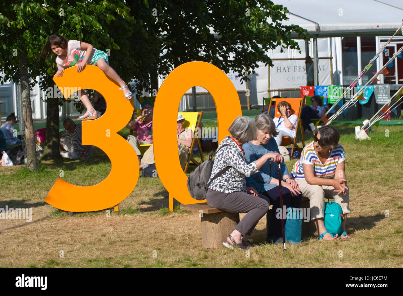 Children playing on Hay 30 sign & senior ladies chatting at Hay Festival 2017 Hay-on-Wye Powys Wales UK Stock Photo