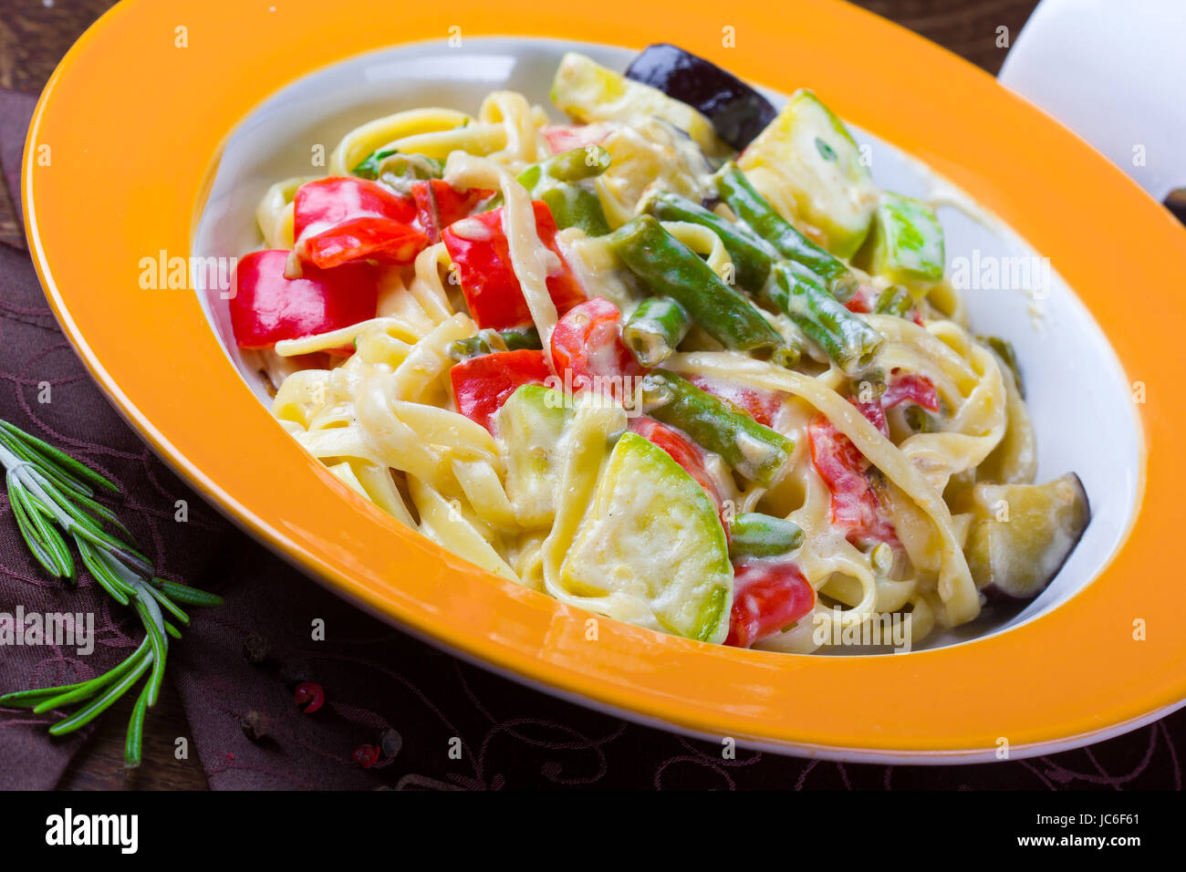 Italian vegetarian pasta with sauce and vegetables, served on a plate Stock Photo