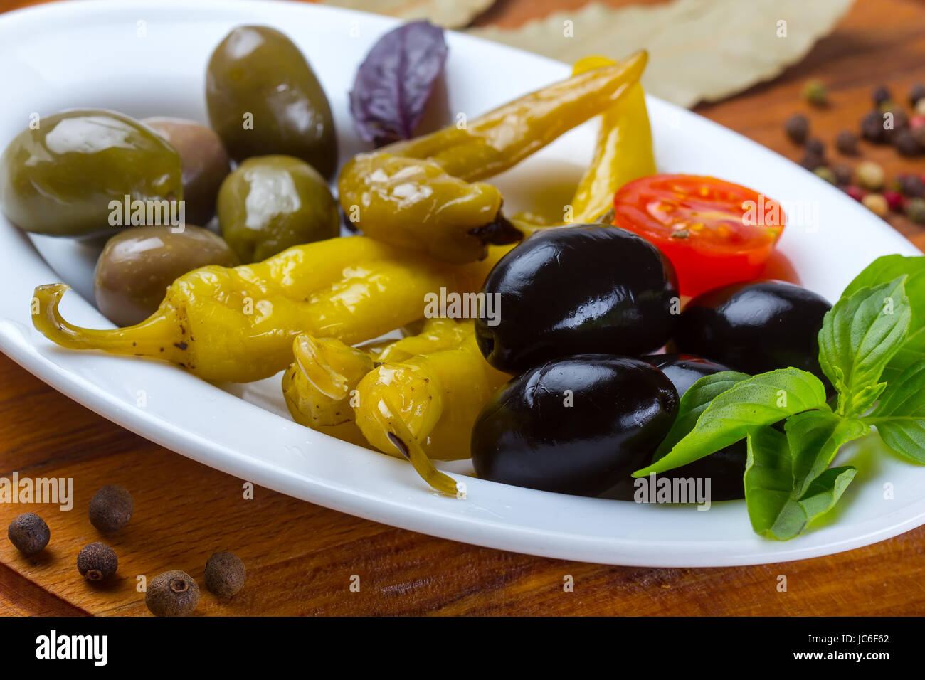 Plate with grilled pepper, assorted olives and spices Stock Photo