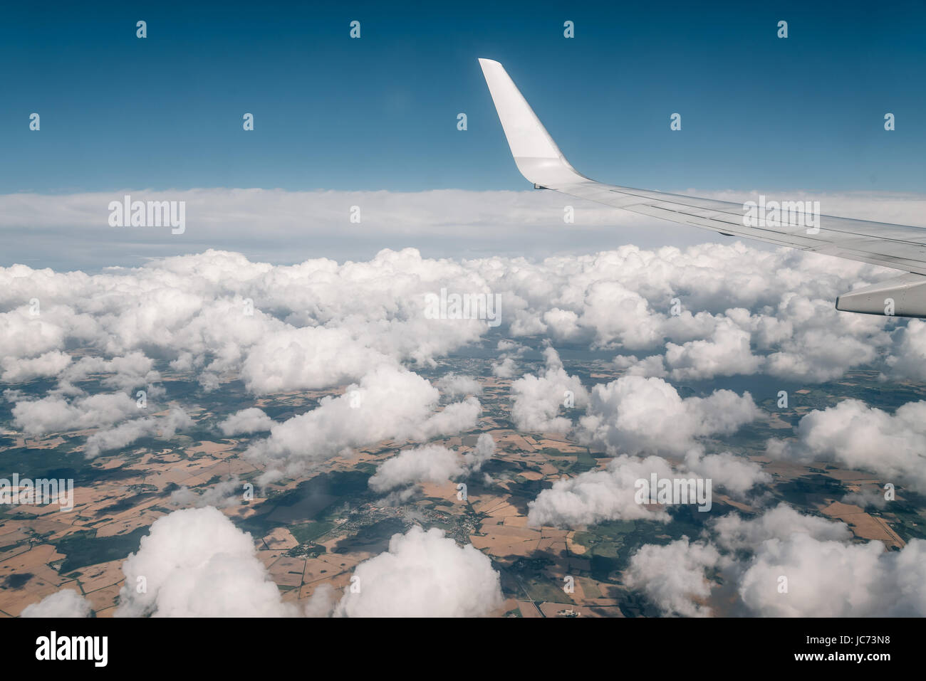 Wing of an airplane flying above the clouds Stock Photo - Alamy