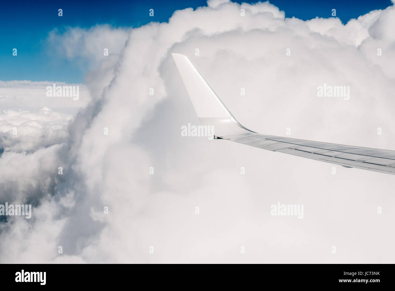 Wing of an airplane flying above the clouds Stock Photo - Alamy
