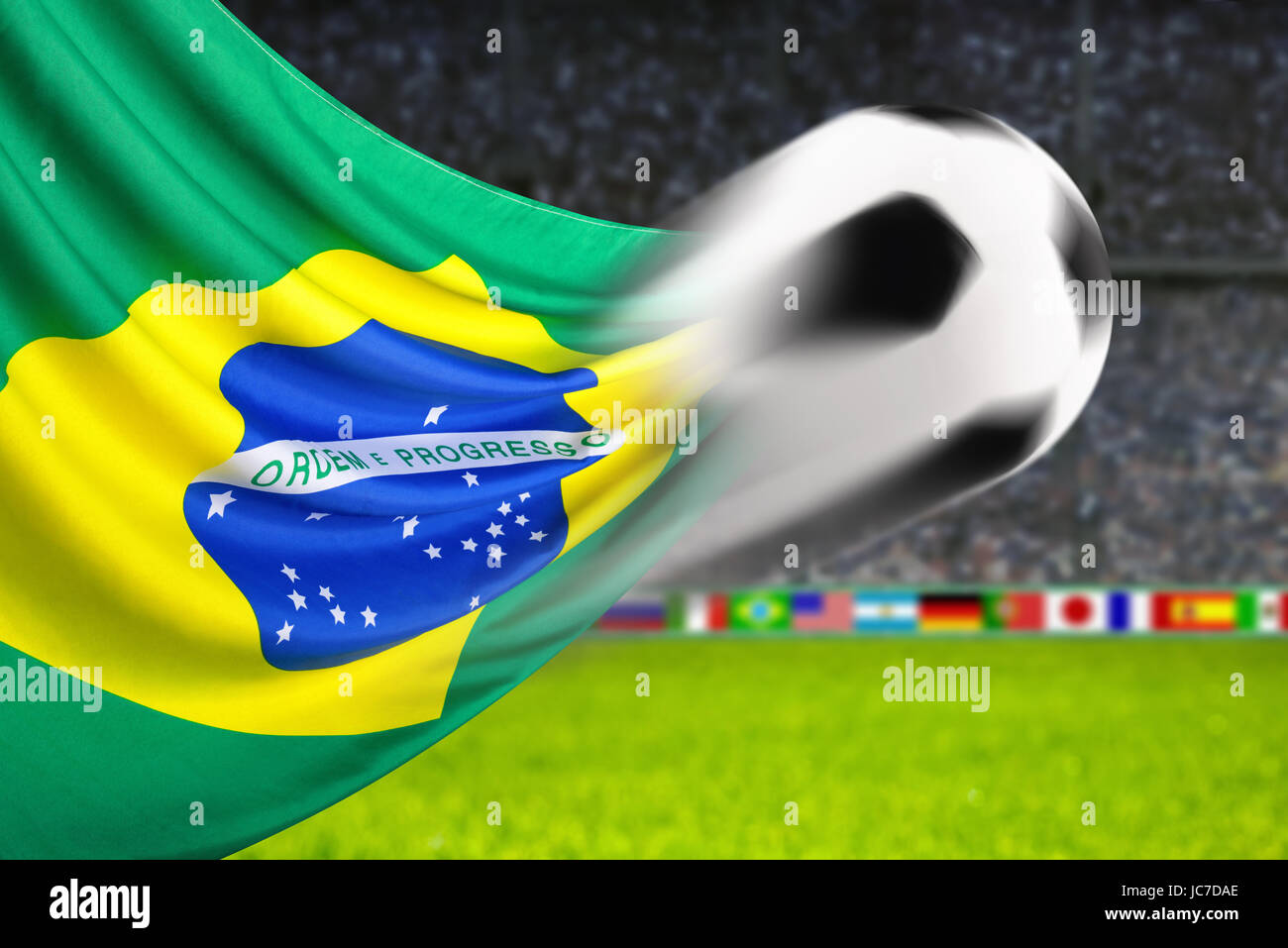 Fußball fliegt vor wehender brasilianischer Flagge Stock Photo