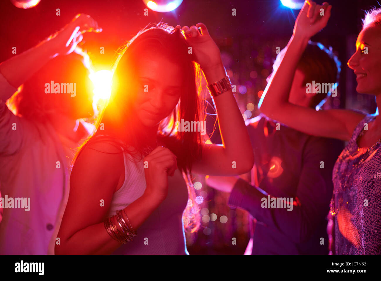 Pretty girls dancing in night club on background of guys Stock Photo - Alamy