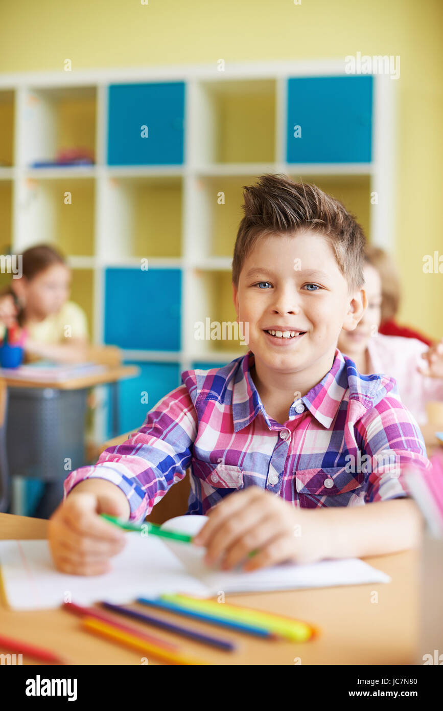 Portrait of a cute schoolboy looking at camera at lesson Stock Photo ...