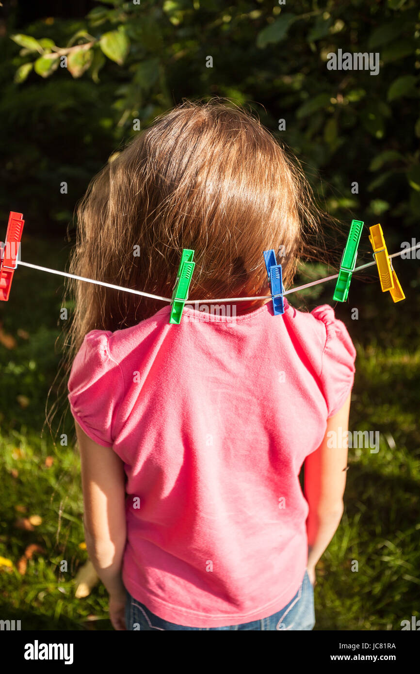 little girl hanged funny shot of girl being hanged by shirt on clothesline Stock Photo - Alamy