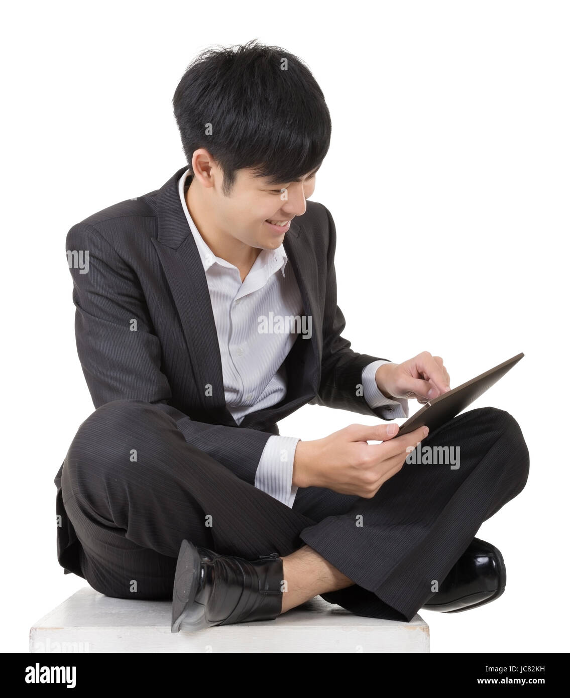 Handsome Asian guy sit and use pad, full length portrait isolated on ...