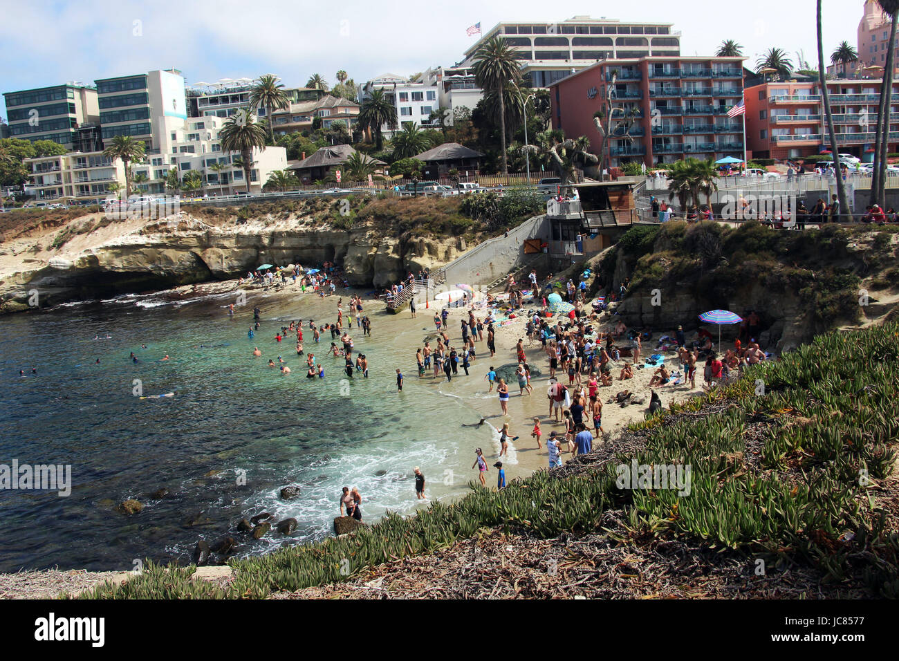 Vacationers hanging out at the crowded Beach on a summer day in La Jolla Cove, San Diego, California. The picture was taken in July 2016. Stock Photo