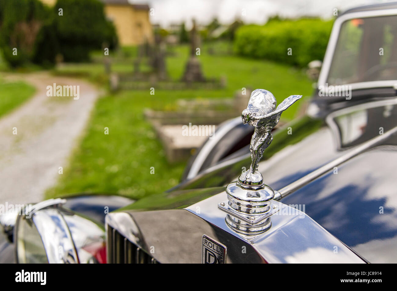 Rolls Royce Silver Lady figurine on a 1938 Rolls Royce Wraith parked in a church graveyard. Stock Photo