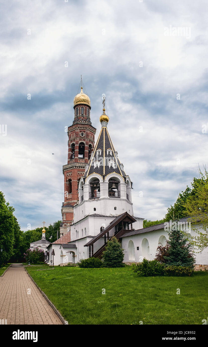 Ancient Orthodox Church with Golden domes and white stone bell tower in the monastery of the Ryazan region. Stock Photo